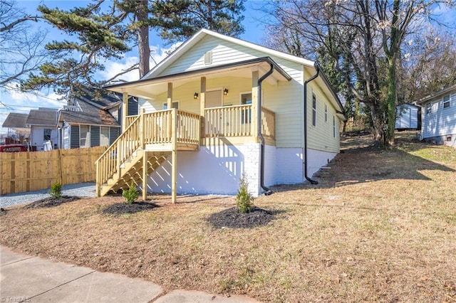 bungalow with a porch and a front lawn