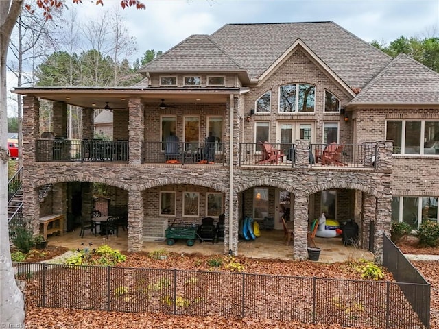 rear view of house with ceiling fan, a balcony, and a patio