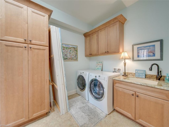 laundry room featuring cabinets, independent washer and dryer, and sink