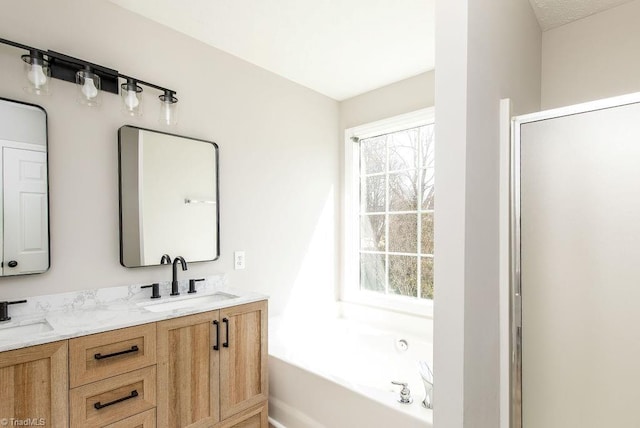 full bath featuring a garden tub, plenty of natural light, and a sink