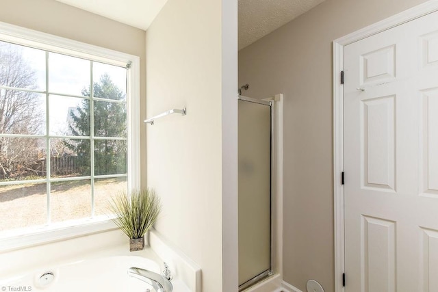 full bathroom with a stall shower, a garden tub, and a textured ceiling