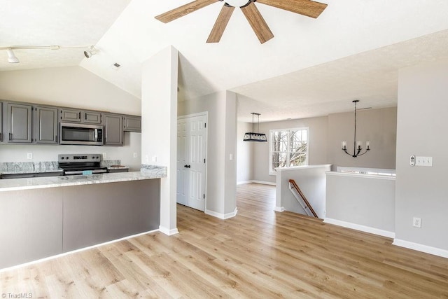 kitchen with baseboards, light wood-style flooring, appliances with stainless steel finishes, gray cabinets, and vaulted ceiling