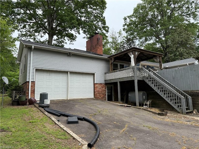 2800 Loch Dr, Winston-Salem, NC 27106 - back of property featuring oil tank, brick siding, driveway, and a chimney