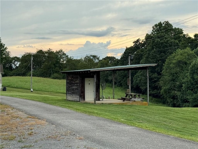 outdoor structure at dusk featuring a lawn