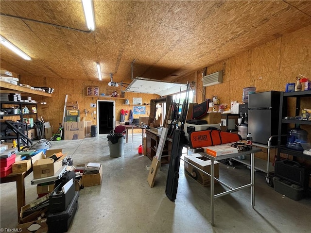 garage featuring refrigerator, a workshop area, and a garage door opener