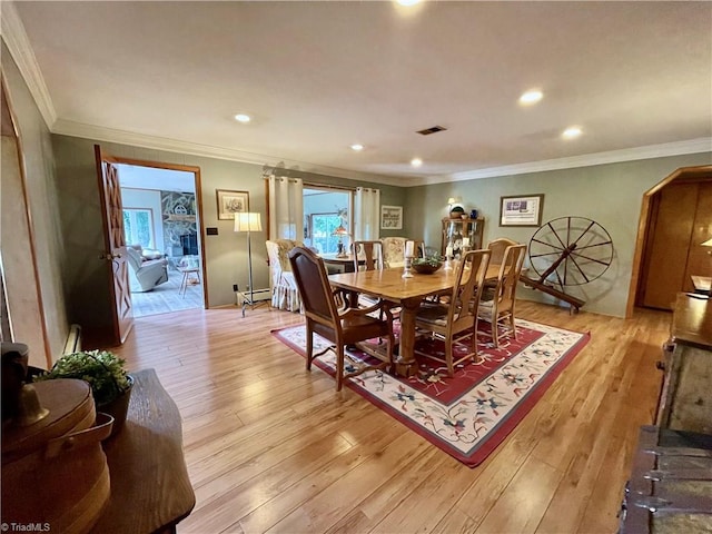 dining room featuring ornamental molding and light wood-type flooring