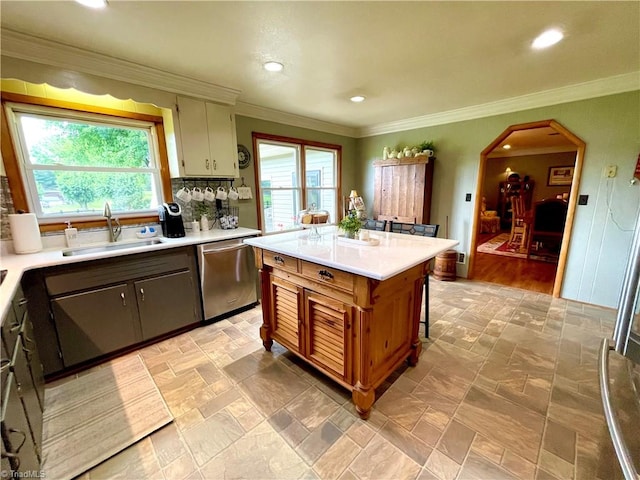 kitchen featuring decorative backsplash, stainless steel dishwasher, light hardwood / wood-style flooring, sink, and crown molding