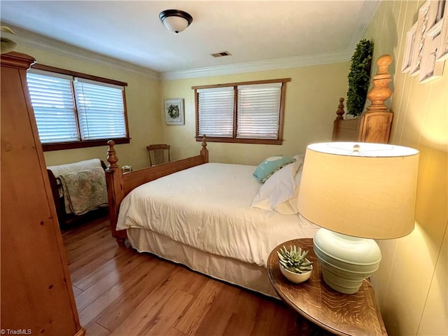 bedroom featuring crown molding and hardwood / wood-style flooring