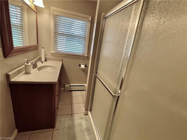 bathroom featuring tile patterned flooring, baseboard heating, vanity, and a healthy amount of sunlight