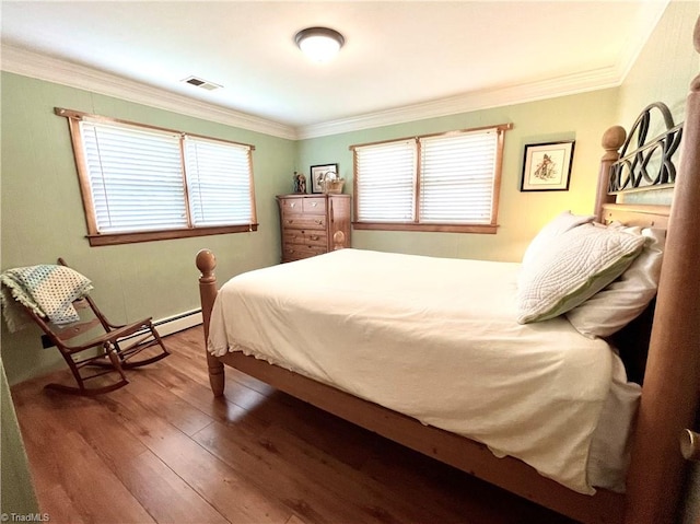 bedroom featuring baseboard heating, crown molding, and hardwood / wood-style floors