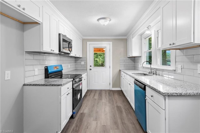 kitchen with white cabinetry, sink, light stone counters, and stainless steel appliances