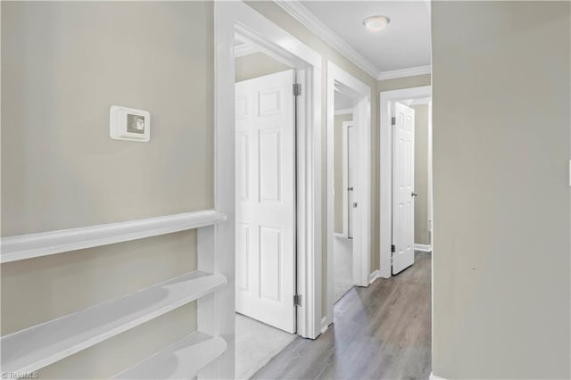 corridor with crown molding and light hardwood / wood-style floors