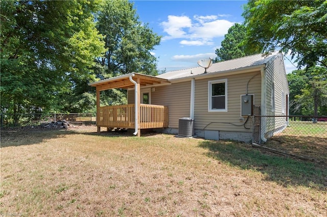 back of house with a wooden deck, central air condition unit, and a lawn