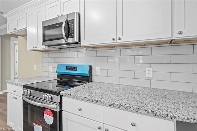 kitchen featuring backsplash, stainless steel appliances, light stone countertops, white cabinets, and dark hardwood / wood-style flooring