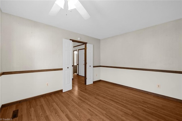 spare room featuring ceiling fan and dark wood-type flooring