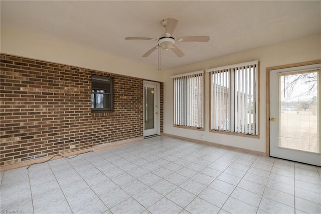 unfurnished sunroom featuring ceiling fan