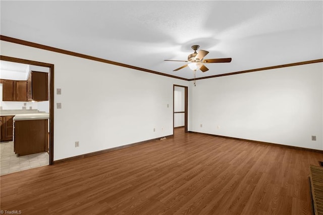 unfurnished room featuring ceiling fan, light hardwood / wood-style floors, and crown molding