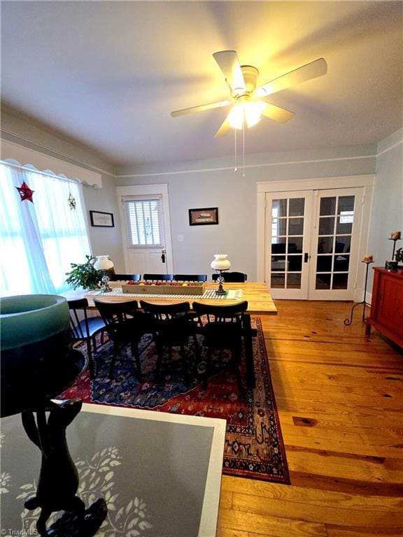 dining room with a ceiling fan, hardwood / wood-style floors, and french doors