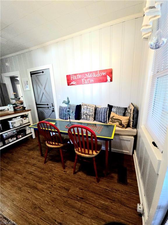 dining space with breakfast area, crown molding, and wood finished floors