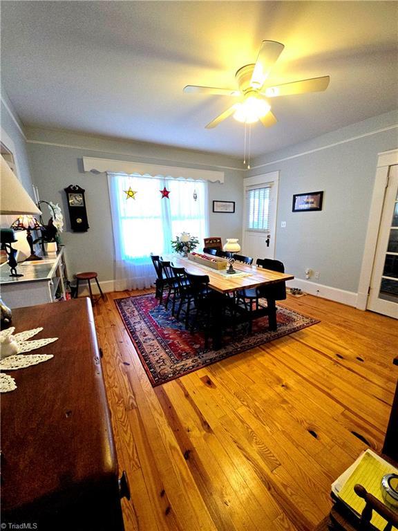 dining room with light wood-style flooring, baseboards, and ceiling fan