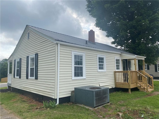 7 Crutchfield Ave, Lexington, NC 28445 - back of property with central AC unit, a chimney, metal roof, and a lawn