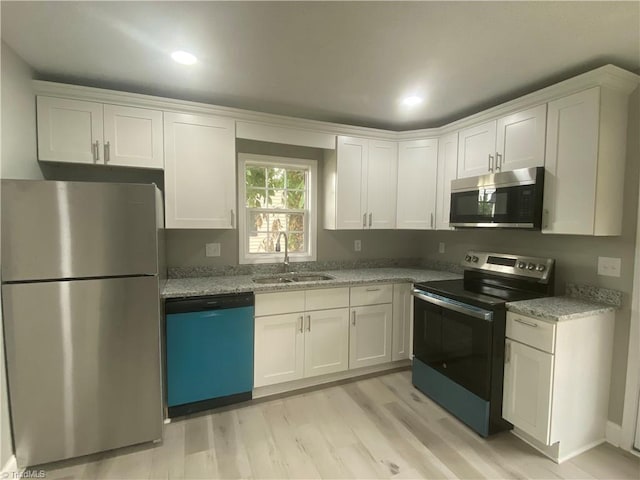 7 Crutchfield Ave, Lexington, NC 28445 - kitchen featuring stainless steel appliances, a sink, white cabinets, light wood-type flooring, and light stone countertops