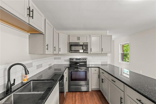 212 Lakeview Dr E, Thomasville, NC 27360 - kitchen featuring appliances with stainless steel finishes, tasteful backsplash, dark stone countertops, and dark wood-type flooring