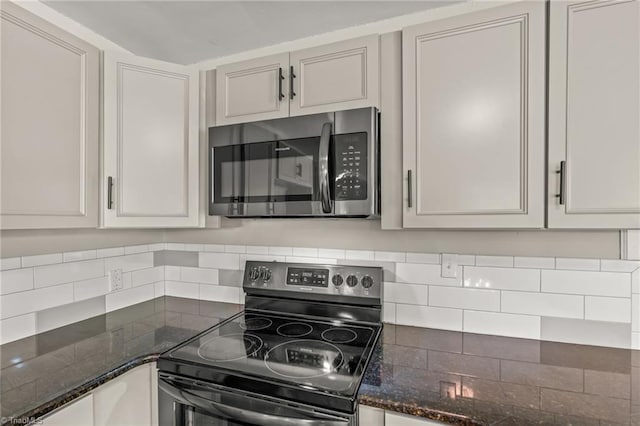212 Lakeview Dr E, Thomasville, NC 27360 - kitchen with stainless steel microwave, electric stove, tasteful backsplash, and dark stone countertops