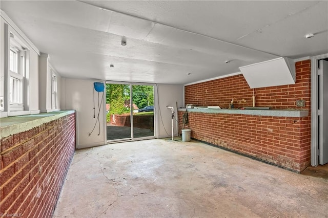 212 Lakeview Dr E, Thomasville, NC 27360 - unfurnished living room featuring brick wall and unfinished concrete flooring