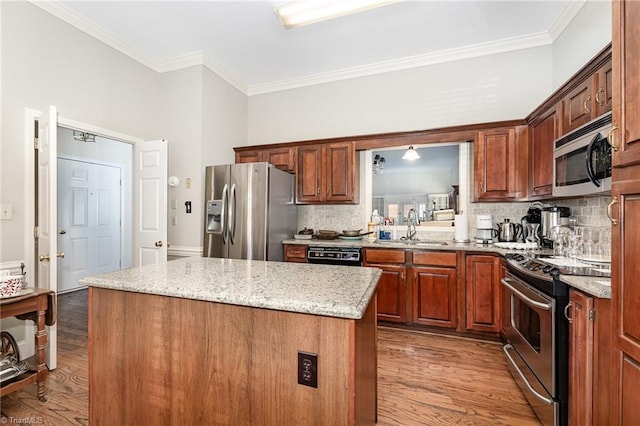 2000 Williamsburg Manor Ct, Winston-Salem, NC 27103 - kitchen with stainless steel appliances, a kitchen island, wood finished floors, decorative backsplash, and crown molding
