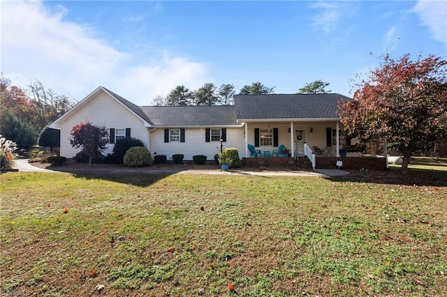 ranch-style house featuring covered porch and a front yard