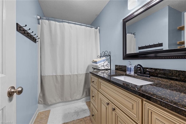 bathroom featuring tile patterned flooring, vanity, curtained shower, and a textured ceiling