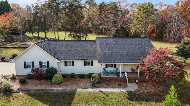 back of property with a lawn and covered porch