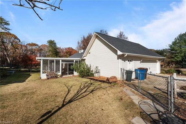 view of side of property featuring a sunroom, a garage, and a lawn