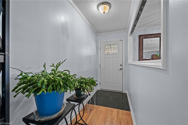 entryway featuring hardwood / wood-style flooring, crown molding, and a textured ceiling