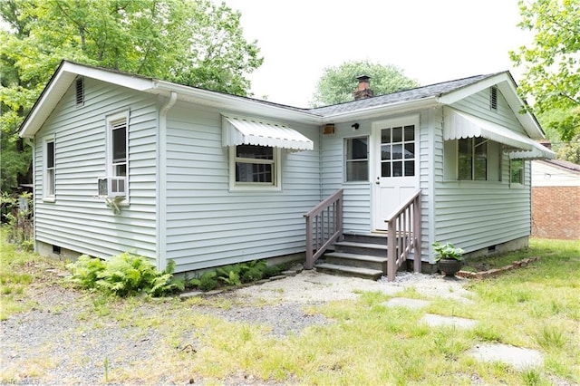 back of property with crawl space, a chimney, and entry steps