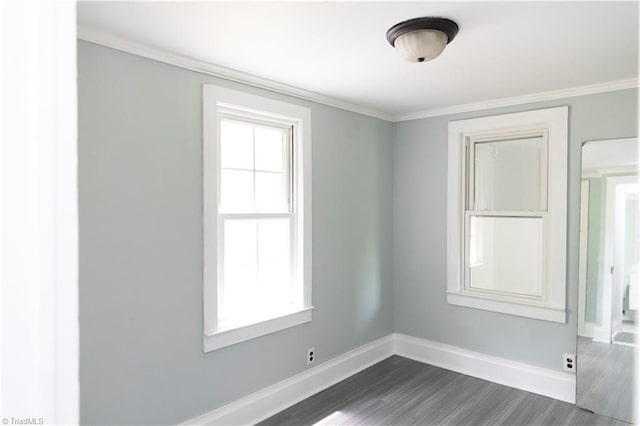 empty room featuring crown molding, baseboards, and dark wood finished floors