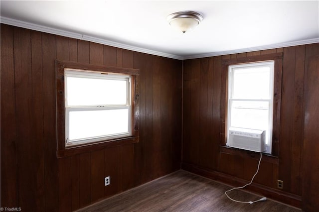 unfurnished room featuring wood walls, a healthy amount of sunlight, and cooling unit
