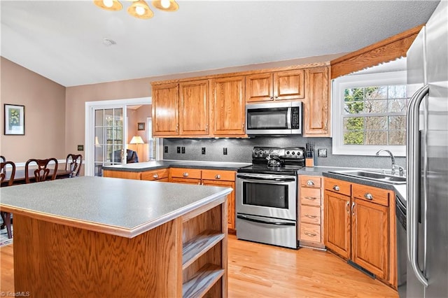 kitchen featuring a healthy amount of sunlight, decorative backsplash, stainless steel appliances, and a sink