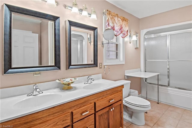 bathroom featuring toilet, tile patterned flooring, double vanity, and a sink