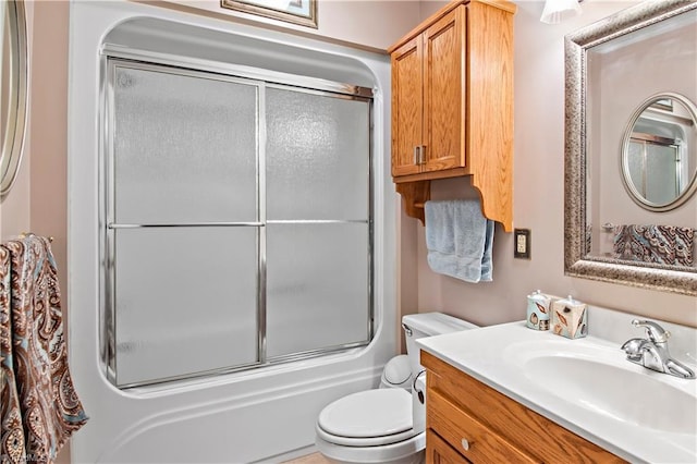 full bath featuring combined bath / shower with glass door, vanity, and toilet