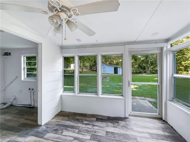 unfurnished sunroom with ceiling fan and a wealth of natural light