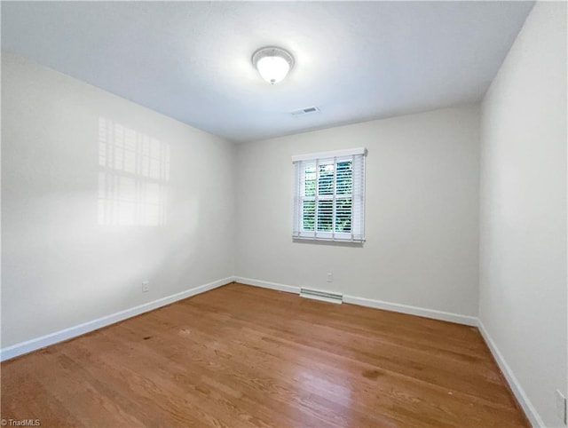 unfurnished room with hardwood / wood-style flooring