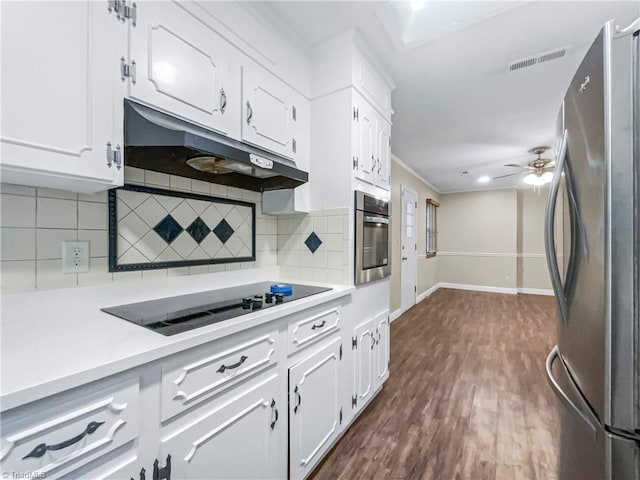 kitchen with white cabinets, appliances with stainless steel finishes, dark hardwood / wood-style flooring, ceiling fan, and decorative backsplash