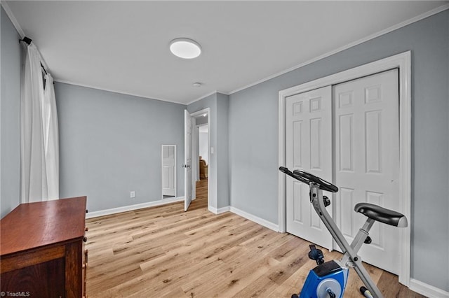 workout area featuring wood finished floors, ornamental molding, and baseboards