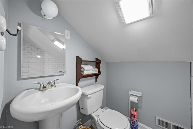 bathroom featuring vaulted ceiling, toilet, and a sink