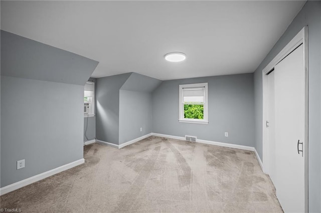 additional living space featuring carpet flooring, baseboards, and lofted ceiling