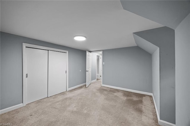 unfurnished bedroom with carpet, a closet, and baseboards