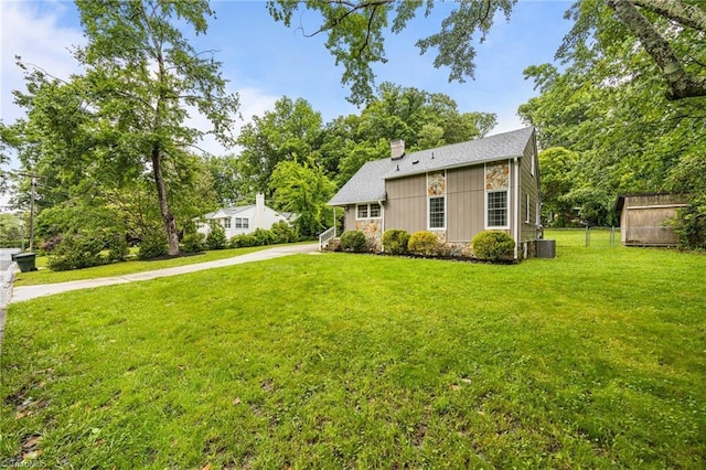 view of front of house with a chimney, concrete driveway, and central air condition unit