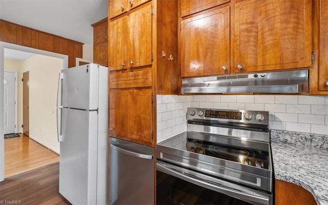 kitchen featuring tasteful backsplash, fridge, stainless steel electric range, dark hardwood / wood-style flooring, and light stone countertops